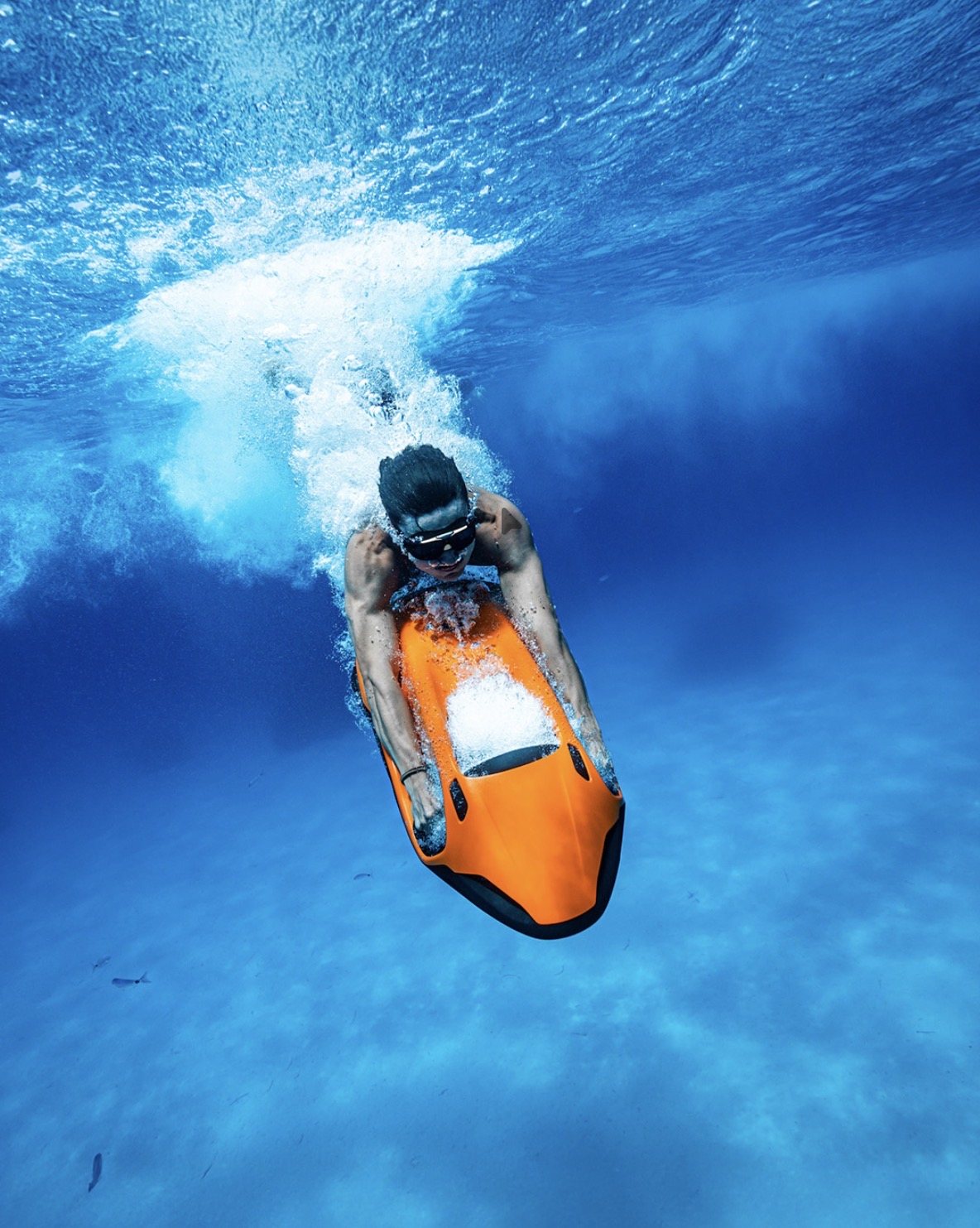 Rider diving head-on with an orange Seabob in clear blue water