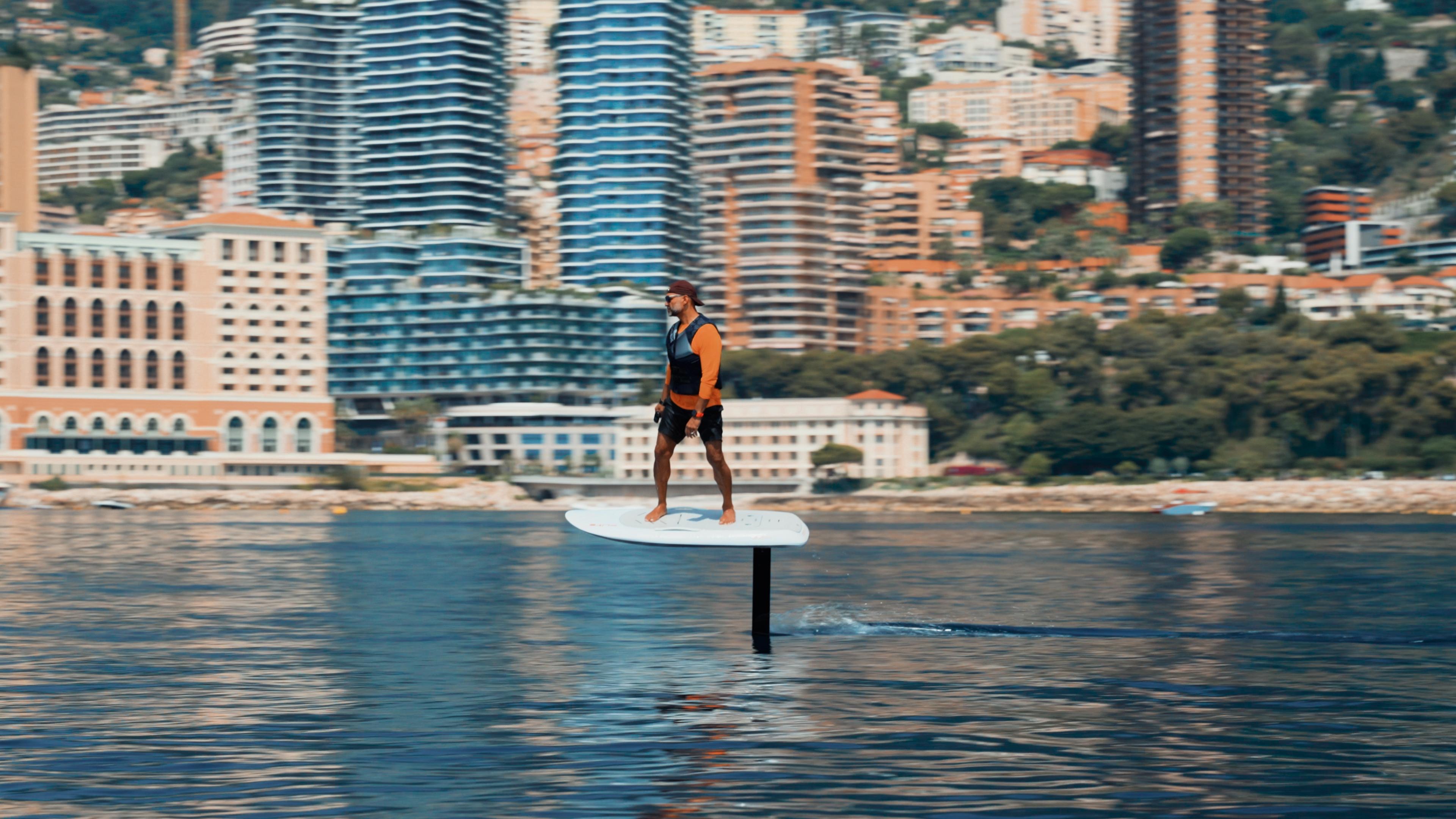 eFoil rider flying above the water in front of a coastal city